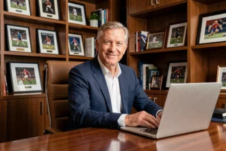 Jean-Pierre Papin, ancien footballeur et ballon d'or, assis dans un bureau élégant symbolisant sa réussite financière après sa carrière sportive