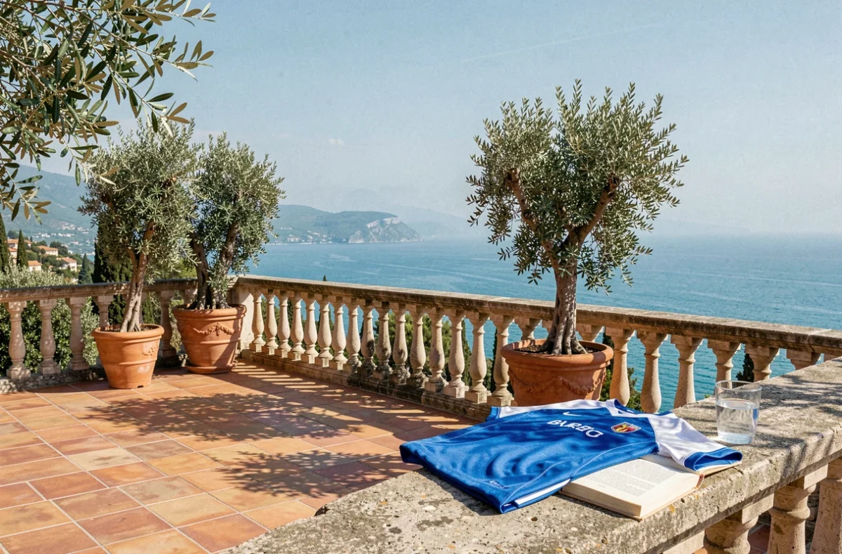 Terrasse de villa méditerranéenne sur la Côte d'Azur avec un maillot de football et un livre biographique, symbolisant la fortune et le style de vie d'un grand champion comme Jean-Pierre Papin